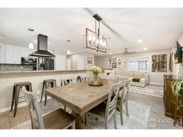 a kitchen with stainless steel appliances kitchen island a table and chairs in it