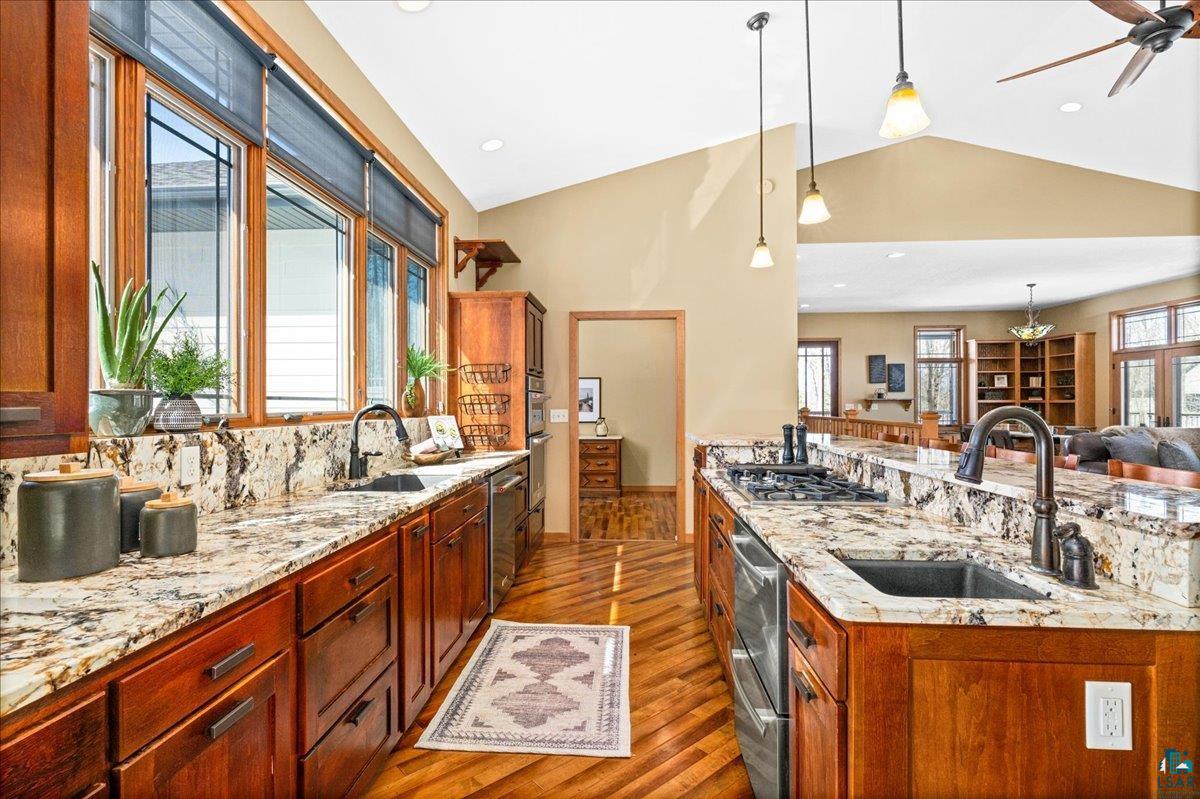 92598 Spells Road Sturgeon Lake, MN 55783 - Photo 60 of 60 Kitchen featuring light stone countertops, open floor plan, dark wood-type flooring, decorative light fixtures, and wood finish cabinetry