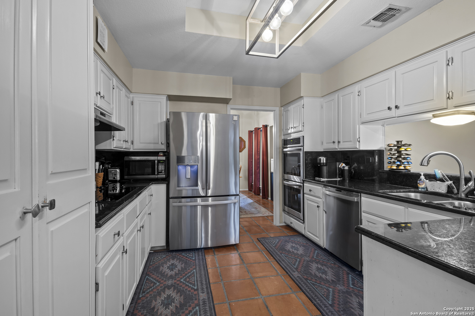12907 Kings Forest Street San Antonio, TX 78230 - Photo 14 of 44 a kitchen with white cabinets and stainless steel appliances