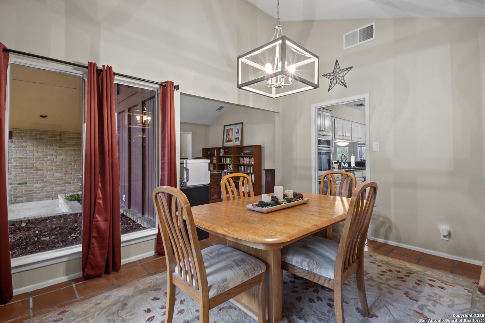 12907 Kings Forest Street San Antonio, TX 78230 - Photo 18 of 44 a view of a dining room with furniture a chandelier and wooden floor