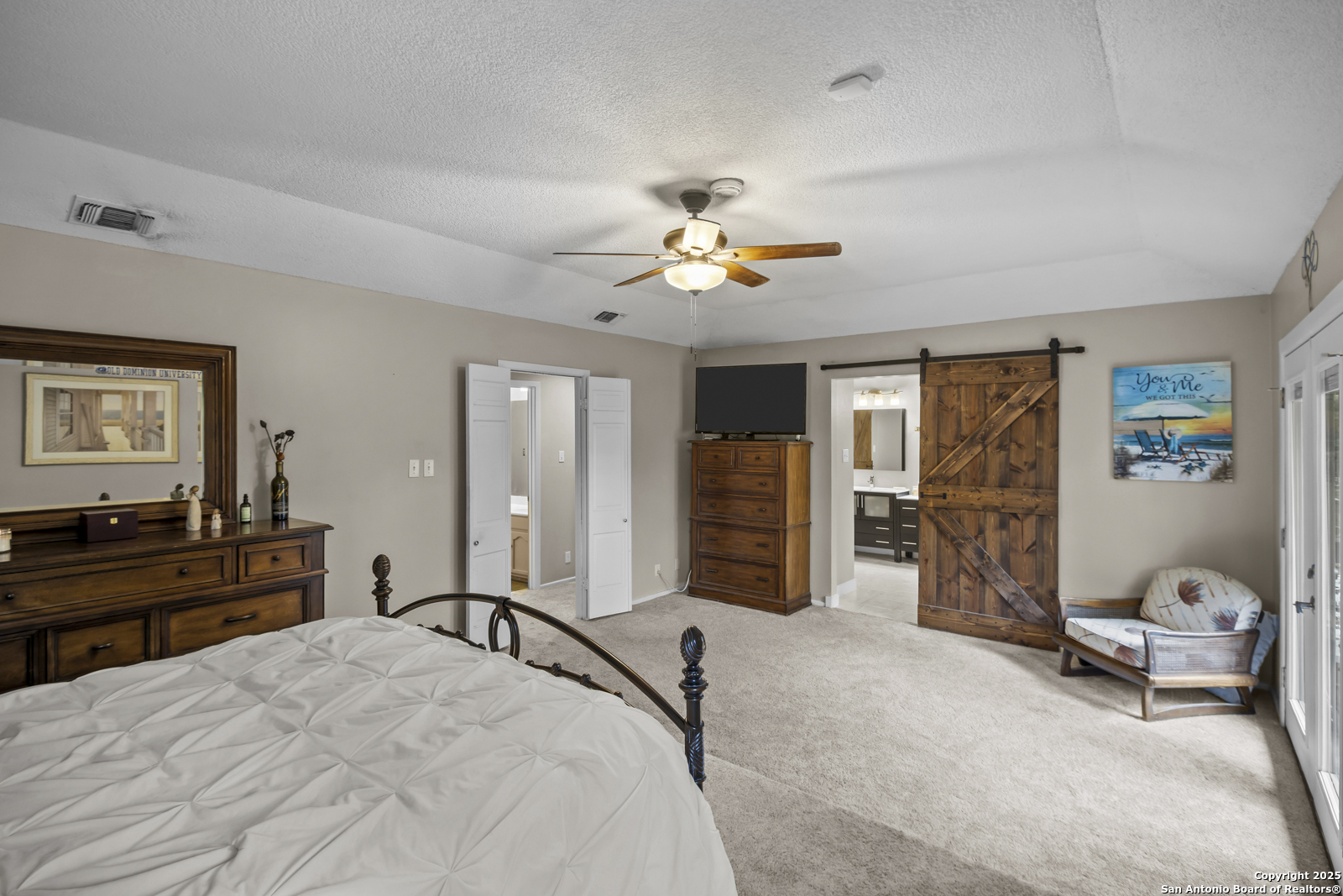 12907 Kings Forest Street San Antonio, TX 78230 - Photo 22 of 44 a bedroom with a bed and dresser with chair