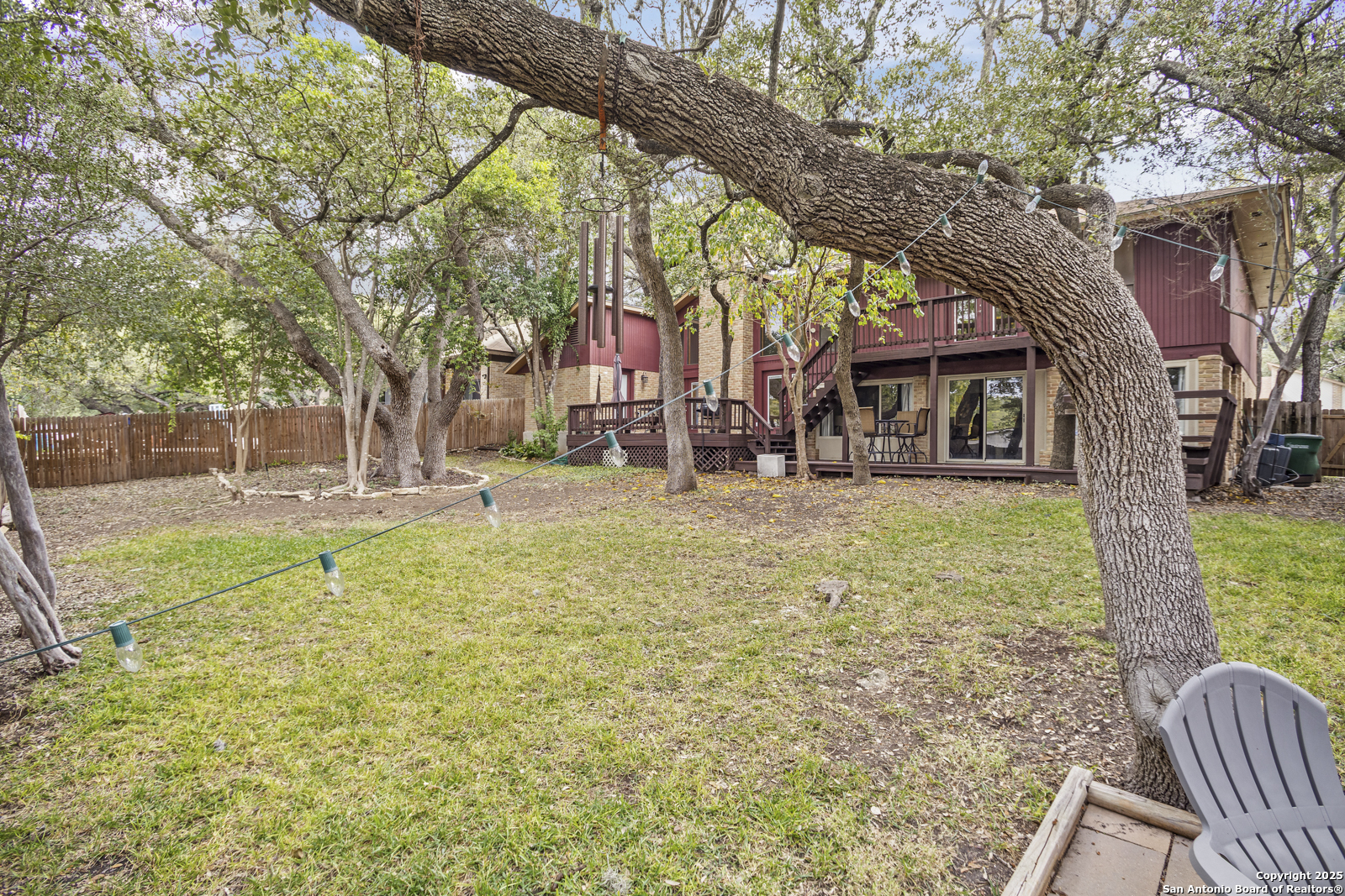 12907 Kings Forest Street San Antonio, TX 78230 - Photo 42 of 44 a backyard of a house with large trees and outdoor seating