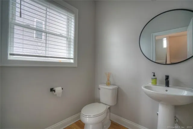 a bathroom with a toilet a sink and a mirror