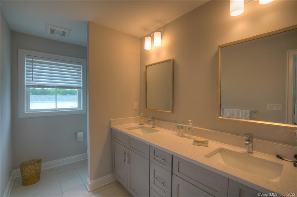 46 Park Avenue, Unit 46 Mystic, CT 06355 - Photo 19 of 28 a bathroom with a double vanity sink and a mirror