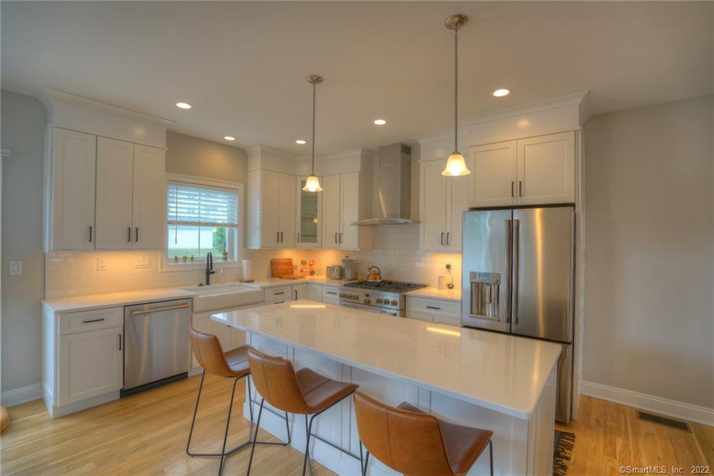 46 Park Avenue, Unit 46 Mystic, CT 06355 - Photo 2 of 28 a kitchen with refrigerator a sink and chairs