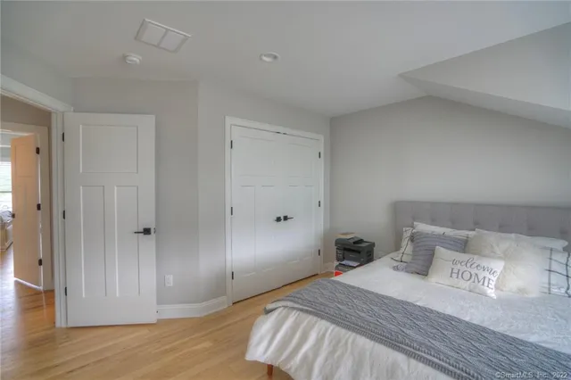 a bedroom with a bed and wooden floor