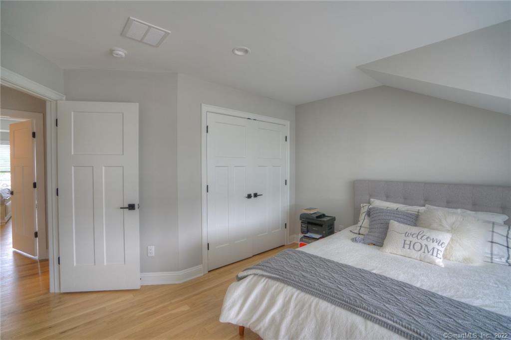 46 Park Avenue, Unit 46 Mystic, CT 06355 - Photo 23 of 28 a bedroom with a bed and wooden floor
