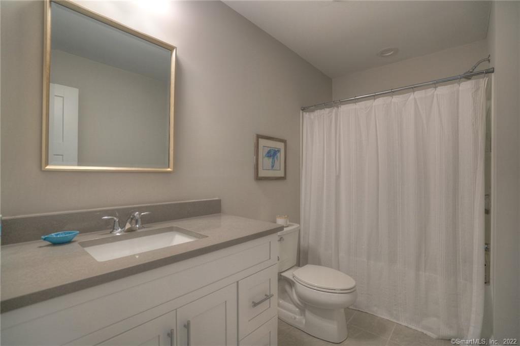 46 Park Avenue, Unit 46 Mystic, CT 06355 - Photo 24 of 28 a bathroom with a granite countertop sink toilet and a mirror