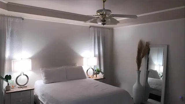 a bedroom with a large bed and a chandelier