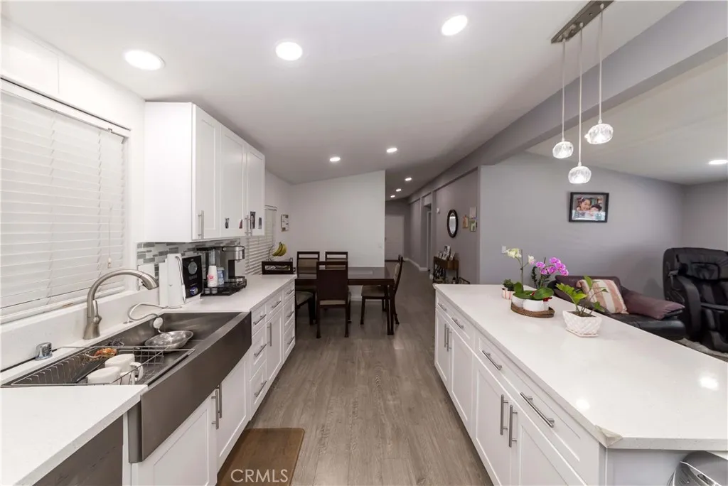 1051 Site, Unit 231 Brea, CA 92821 - Photo 12 of 34 a kitchen that has a lot of cabinets a sink and wooden floor
