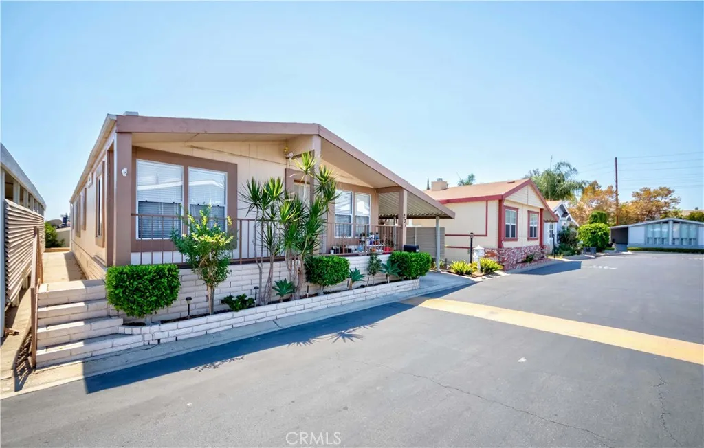1051 Site, Unit 231 Brea, CA 92821 - Photo 3 of 34 a front view of a house with a yard and potted plants
