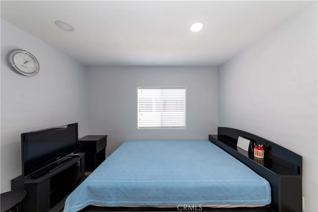 1051 Site, Unit 231 Brea, CA 92821 - Photo 31 of 34 a bedroom with a bed and a flat tv screen on a dresser