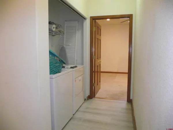 a view of a hallway with wooden floor and cabinet