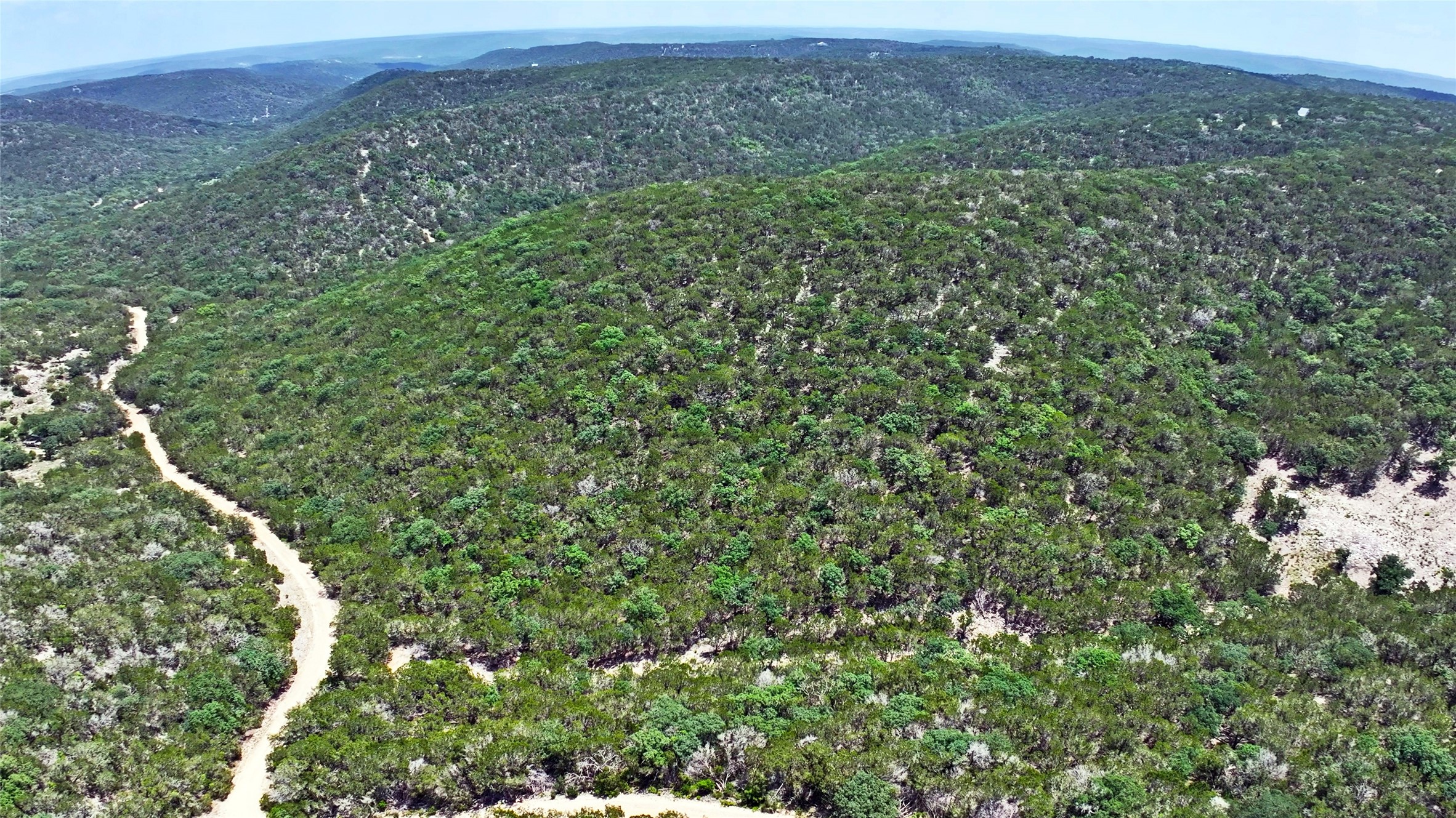 Lot 129 Spring Country Ranch Road Leakey, TX 78873 - Photo 2 of 19 a view of a green field with lots of bushes