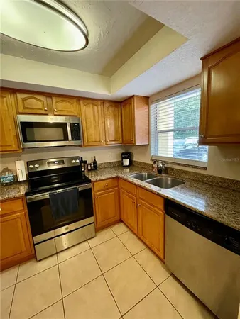 a kitchen with stainless steel appliances granite countertop a stove a sink and a microwave