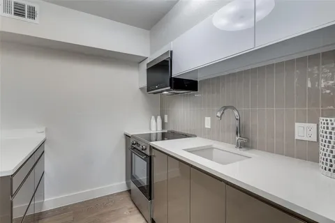 a kitchen with a sink and a stove top oven