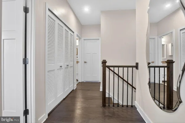 a view of a hallway with wooden floor and stairs