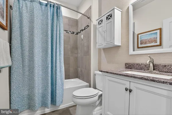 a bathroom with a granite countertop sink toilet and a shower