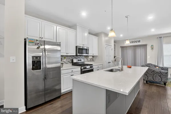 a kitchen that has a lot of cabinets and wooden floor