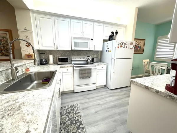 a kitchen with a stove a sink and a refrigerator