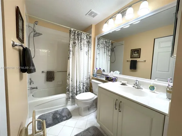 a bathroom with a bathtub shower sink vanity and toilet
