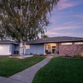 a front view of a house with a garden and yard