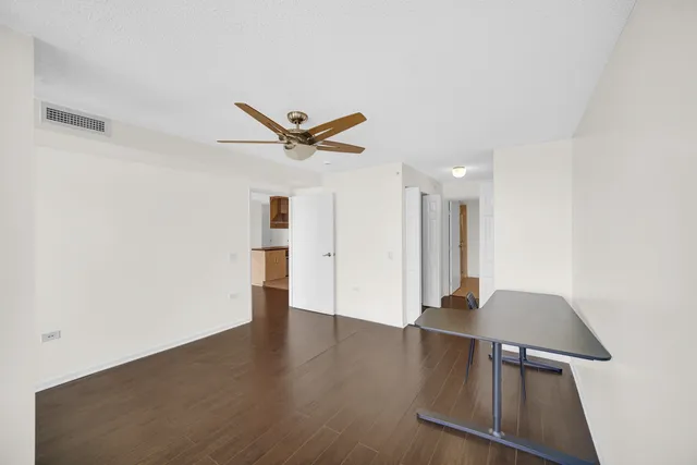 a view of a livingroom with wooden floor and a ceiling fan