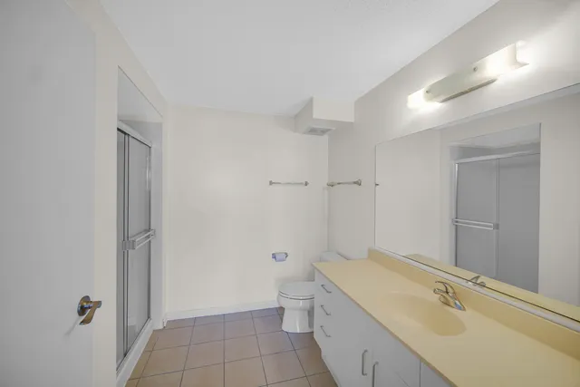 a bathroom with a granite countertop sink a toilet and shower