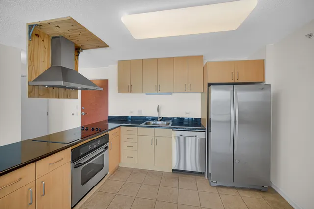 a kitchen with stainless steel appliances granite countertop a sink and a refrigerator