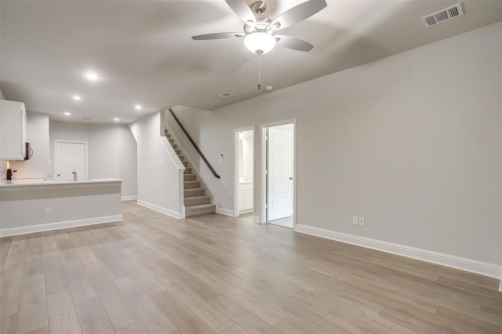 6811 Robert Reed Drive Arlington, TX 76001 - Photo 3 of 34 a view of an empty room with wooden floor and stairs