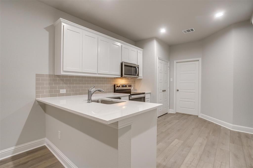 6811 Robert Reed Drive Arlington, TX 76001 - Photo 9 of 34 a kitchen with a sink cabinets and wooden floor