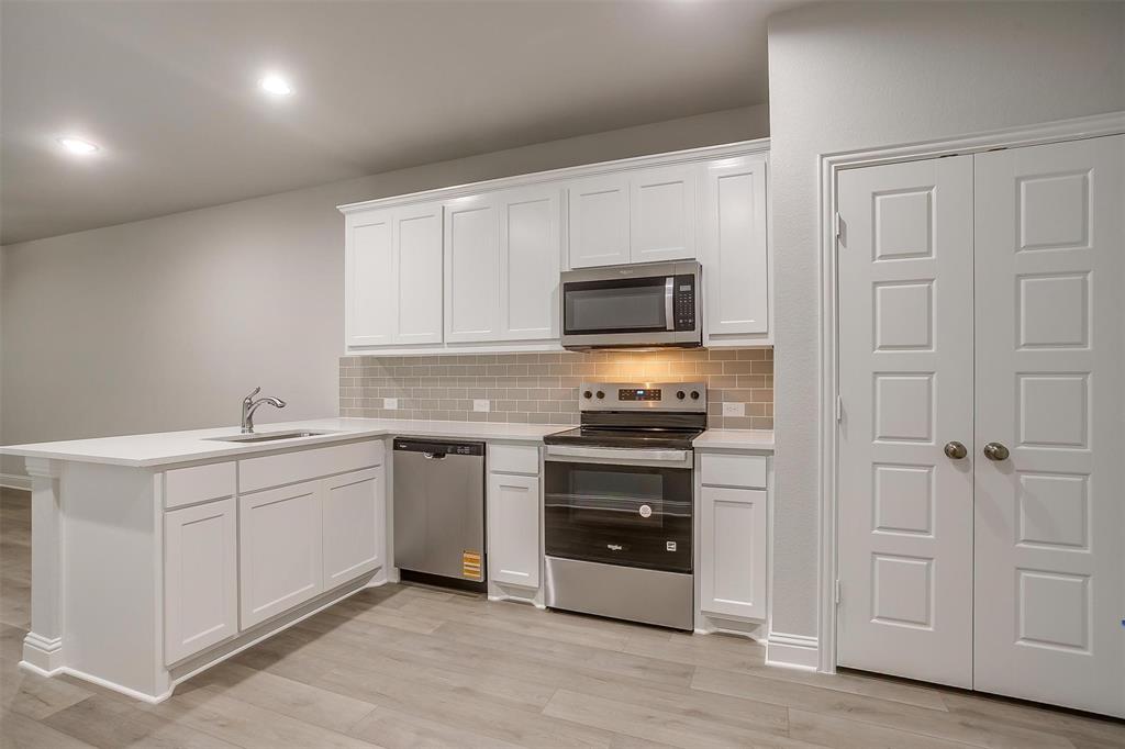 6811 Robert Reed Drive Arlington, TX 76001 - Photo 10 of 34 a kitchen with white cabinets and appliances