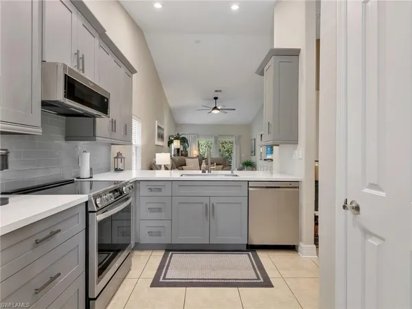 a kitchen with stainless steel appliances granite countertop a sink and dishwasher a stove top oven with white cabinets