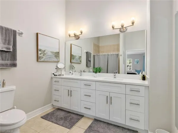 a bathroom with a granite countertop sink a toilet and a mirror