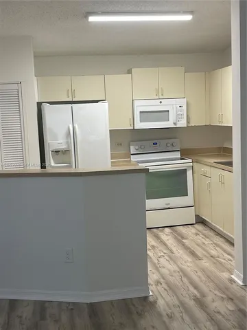 a kitchen with a stove a sink and a microwave