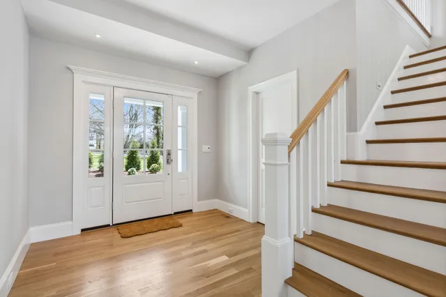 a view of a hallway with wooden floor and stairs