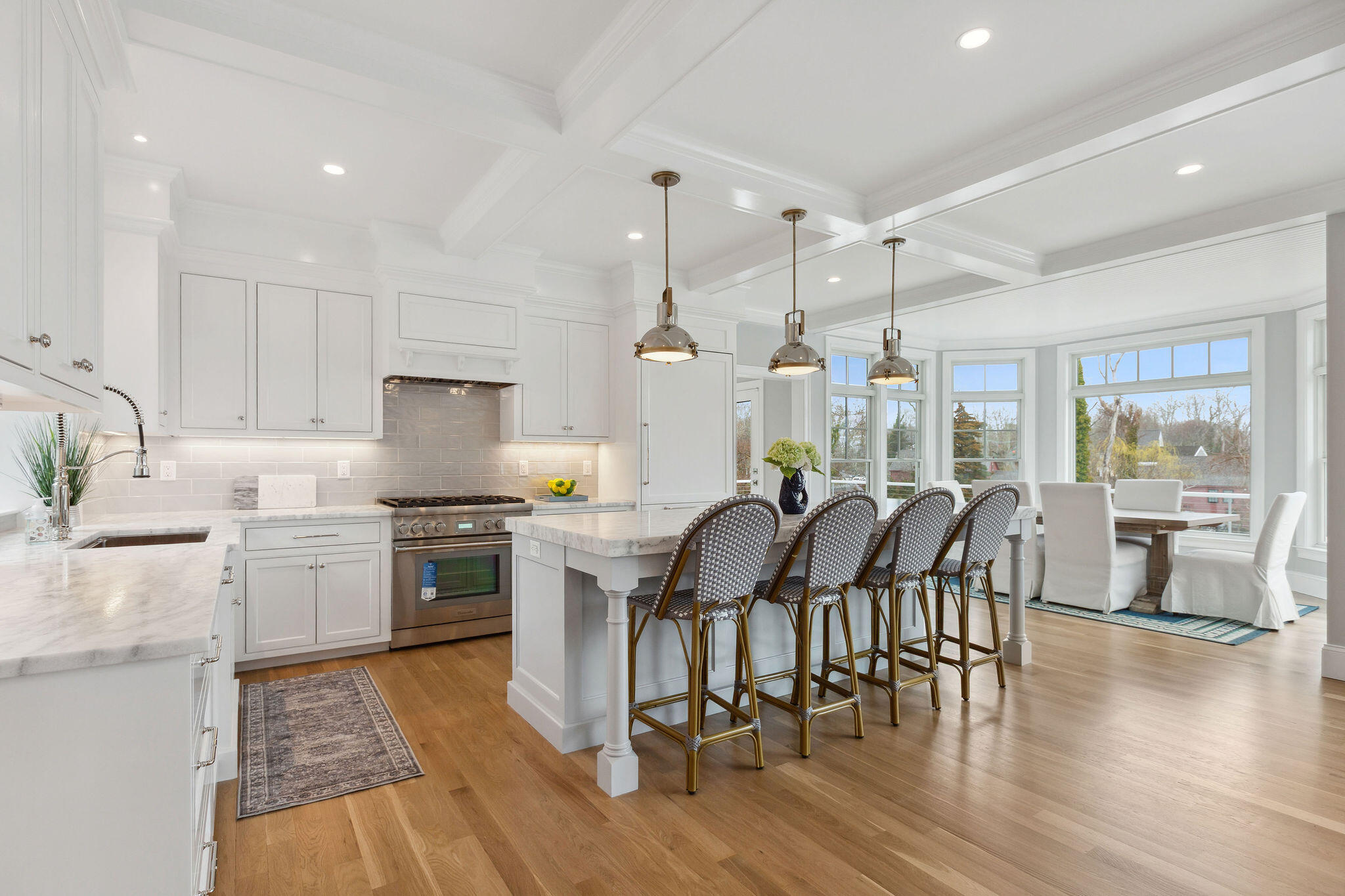 44 Tonset Road Orleans, MA 02653 - Photo 21 of 79 a kitchen with stainless steel appliances granite countertop a stove a refrigerator a kitchen island a dining table and chairs with wooden floor