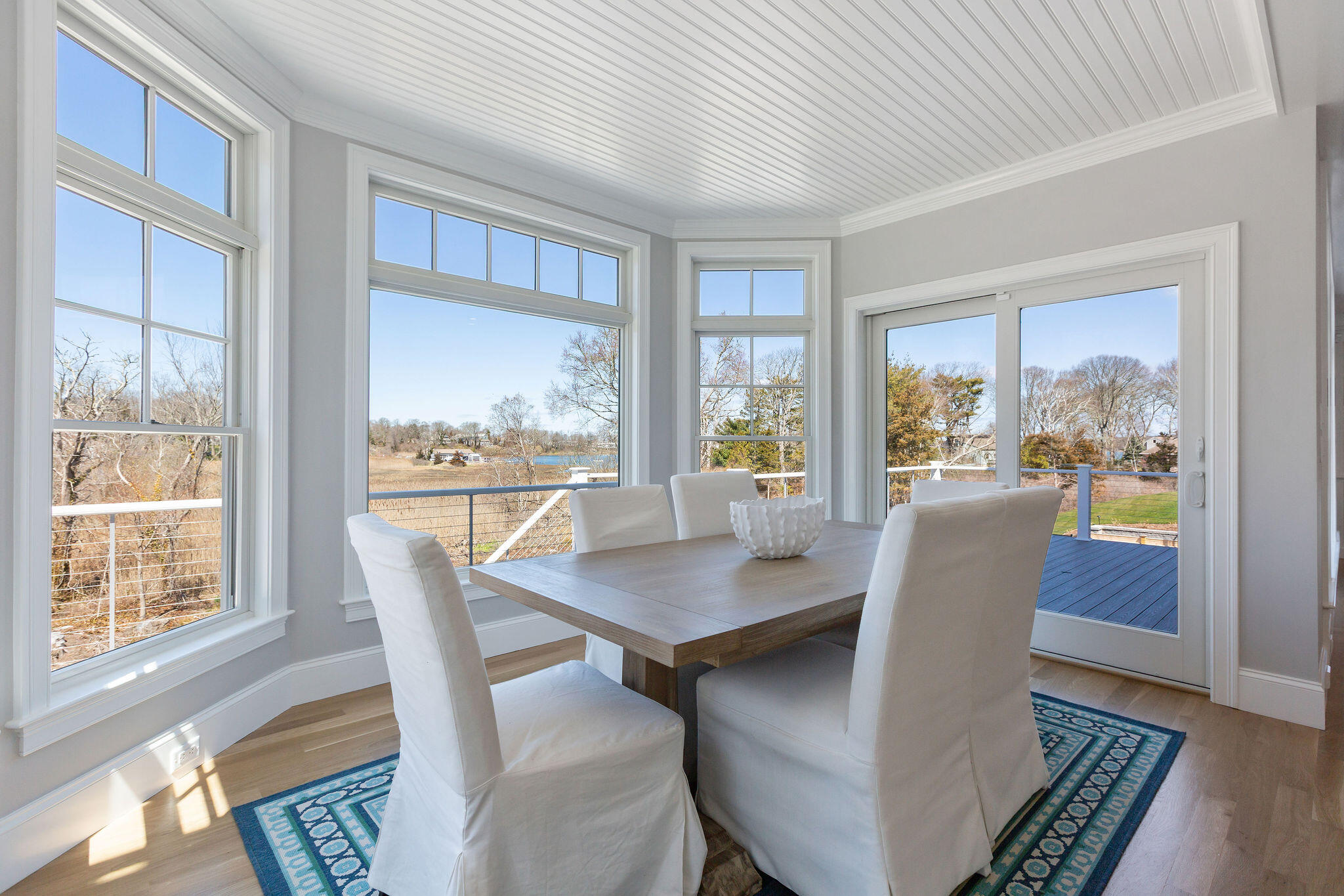 44 Tonset Road Orleans, MA 02653 - Photo 27 of 79 a view of a dining room with furniture large windows and wooden floor