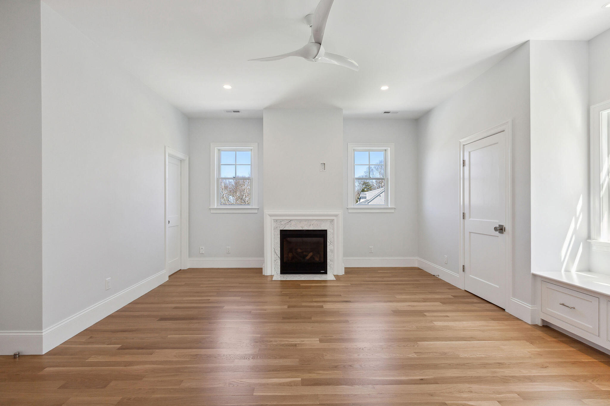 44 Tonset Road Orleans, MA 02653 - Photo 55 of 79 an empty room with wooden floor fireplace and windows