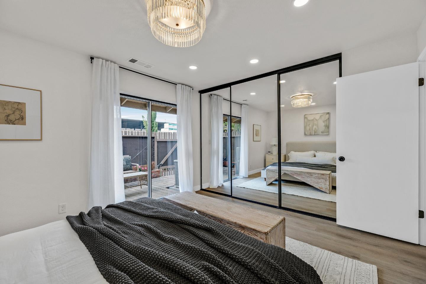 205 Red Oak Drive, Unit M Sunnyvale, CA 94086 - Photo 21 of 32 a bedroom with a bed and a chandelier