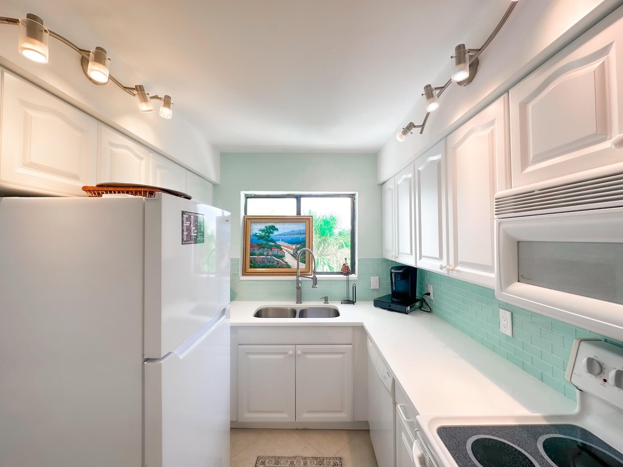 420 Celestial Way, Unit 301 Juno Beach, FL 33408 - Photo 23 of 51 a kitchen with a refrigerator and a sink