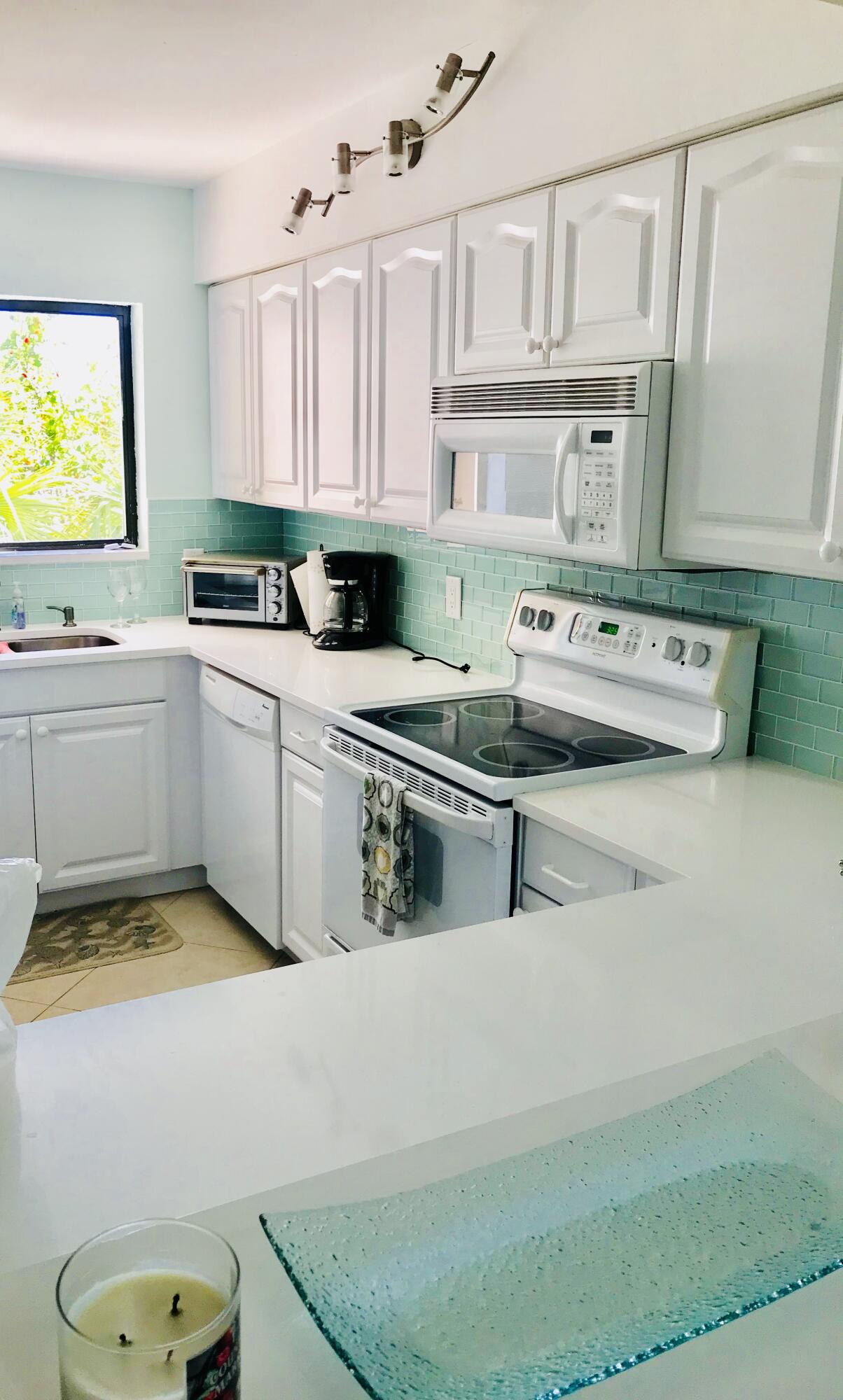 420 Celestial Way, Unit 301 Juno Beach, FL 33408 - Photo 50 of 51 a kitchen with cabinets a sink and appliances
