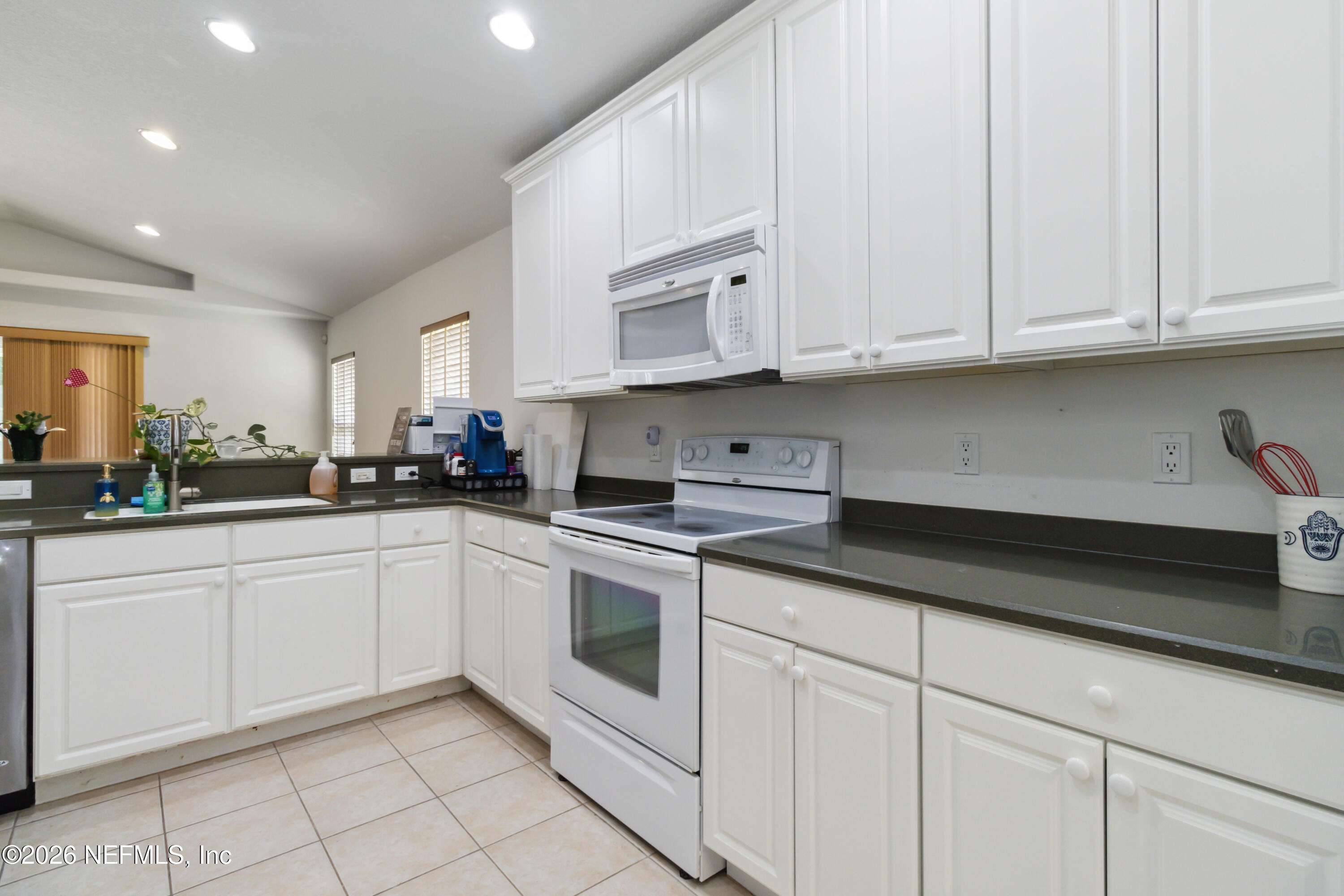 940 Tavernier Circle Northeast Palm Bay, FL 32905 - Photo 13 of 31 a kitchen with white cabinets stainless steel appliances and sink