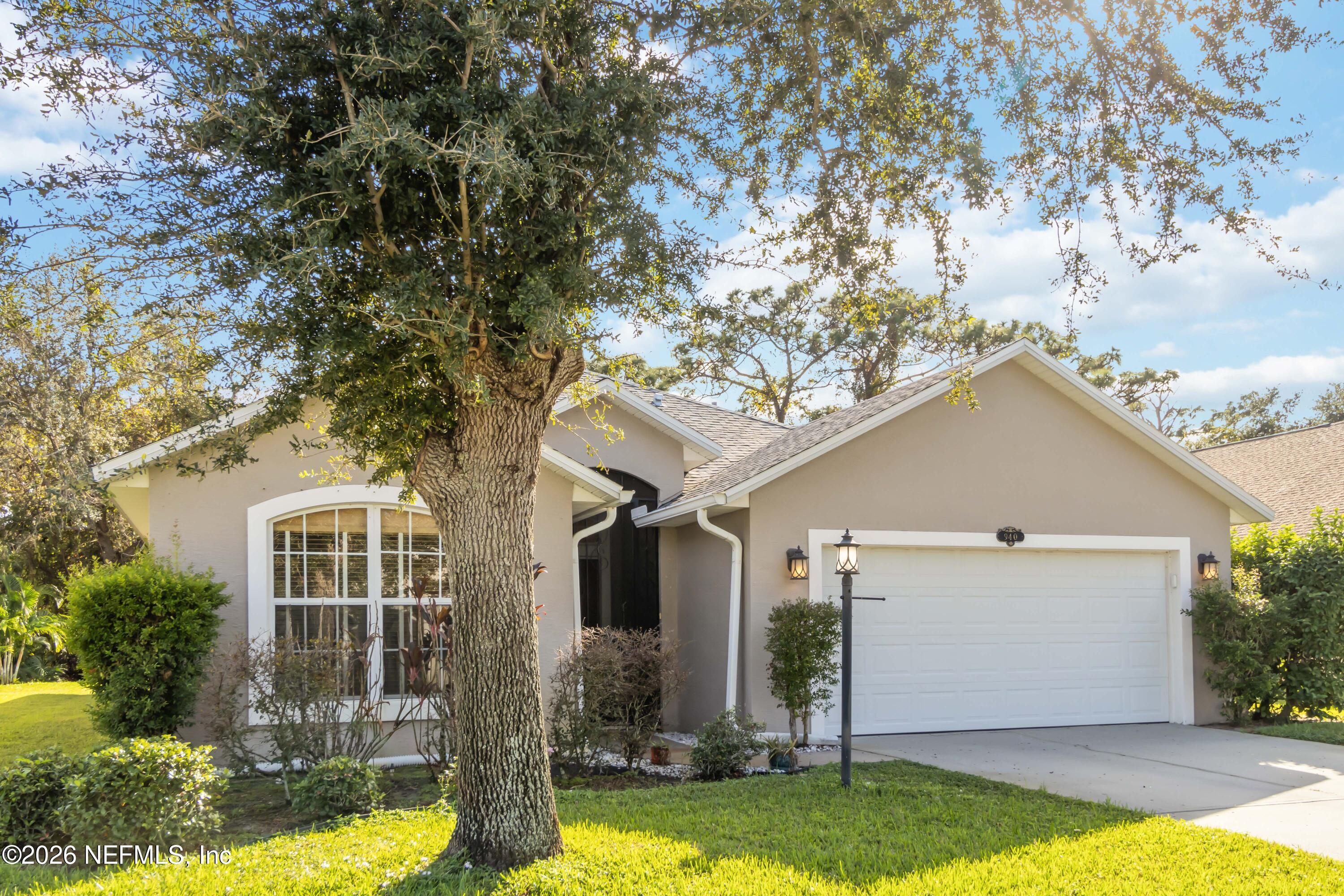 940 Tavernier Circle Northeast Palm Bay, FL 32905 - Photo 2 of 31 a front view of house with yard and trees in the background