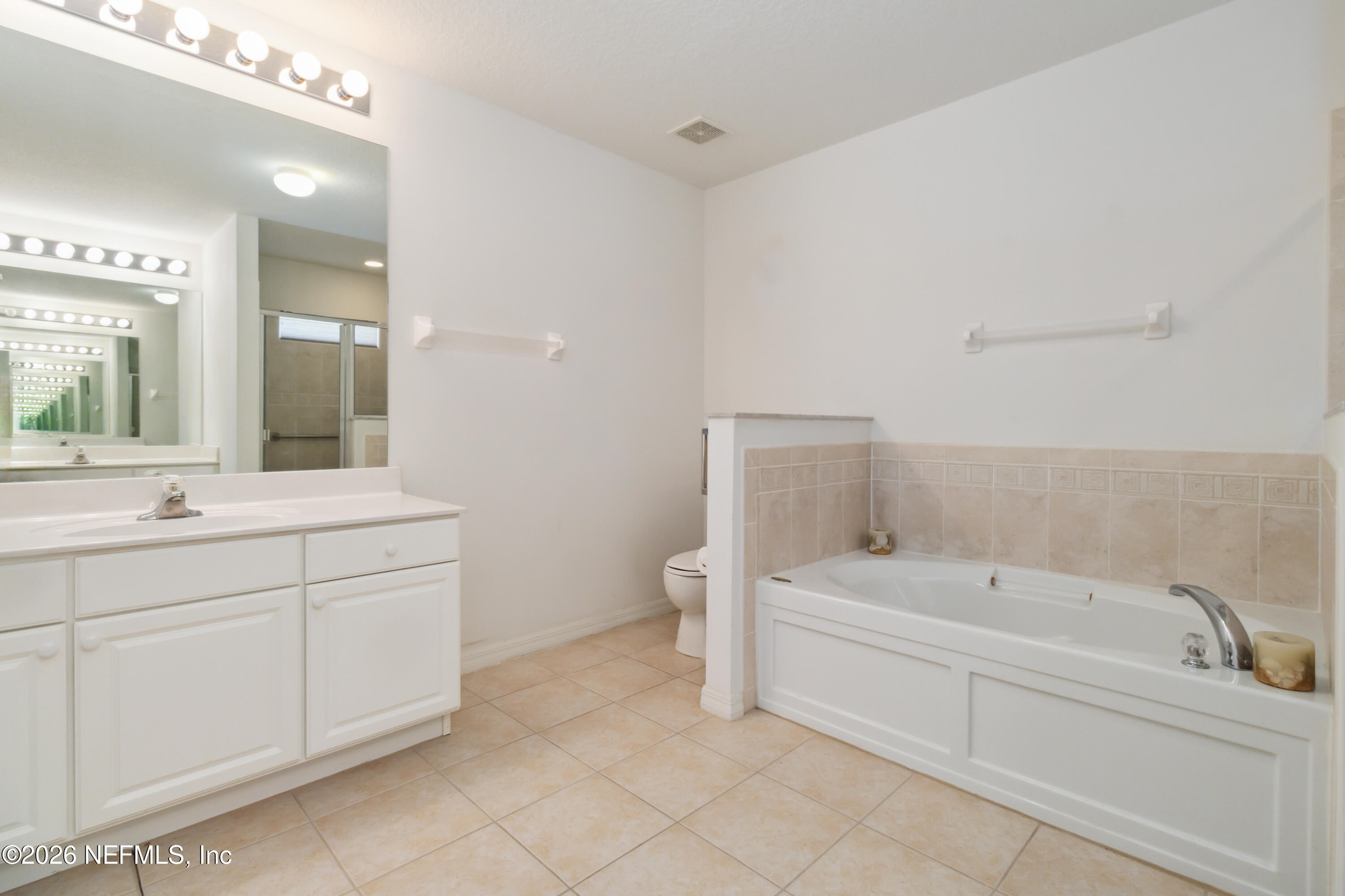 940 Tavernier Circle Northeast Palm Bay, FL 32905 - Photo 23 of 31 a bathroom with a bathtub sink mirror and toilet