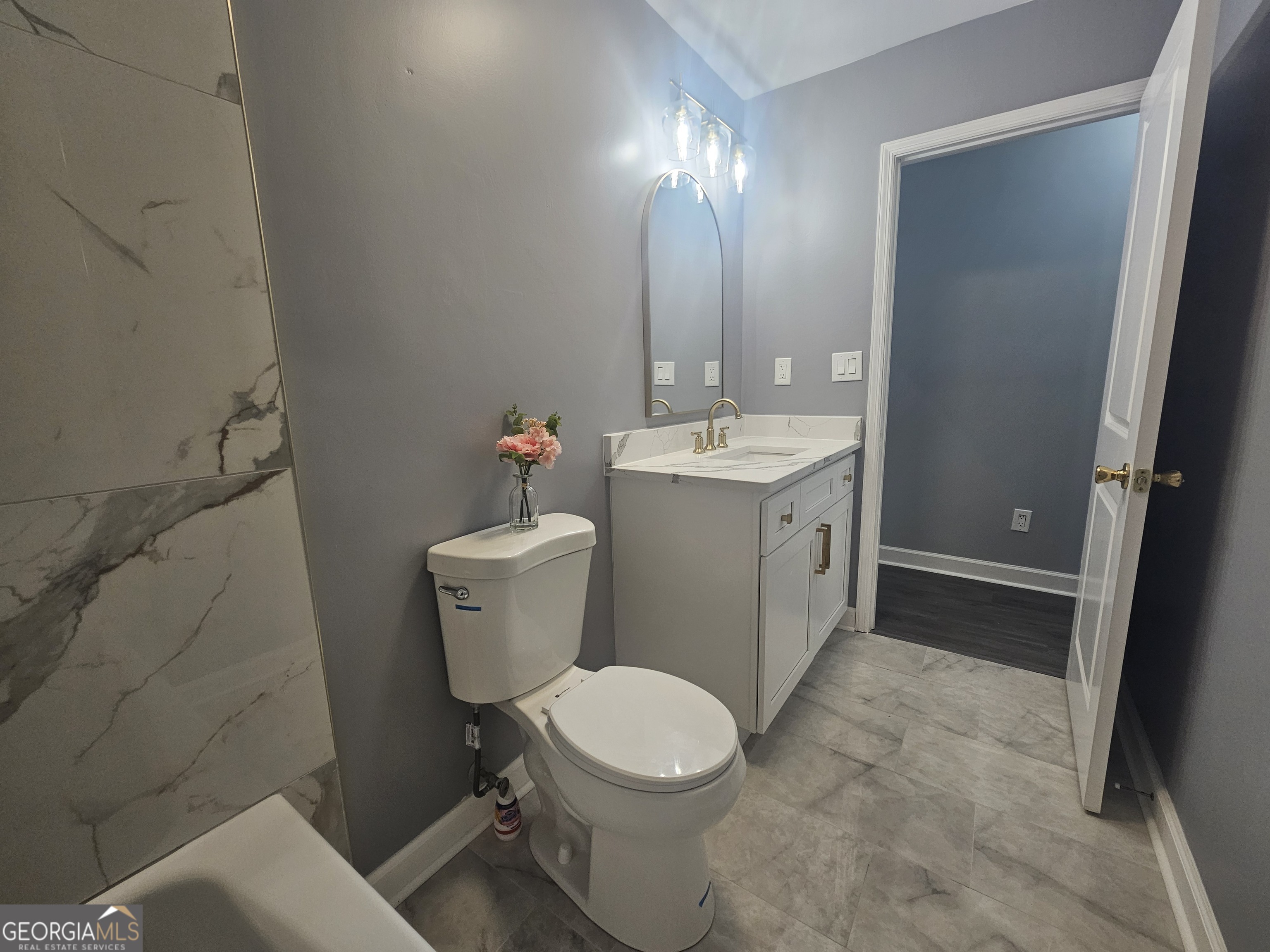 391 Park Ridge Circle Riverdale, GA 30274 - Photo 33 of 42 a white toilet sitting next to a bathroom sink and a mirror