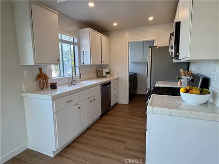 a kitchen with stainless steel appliances a refrigerator sink and wooden cabinets