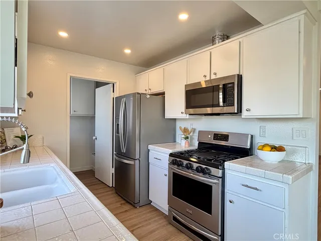 a kitchen with stainless steel appliances a refrigerator a stove top oven a sink and dishwasher