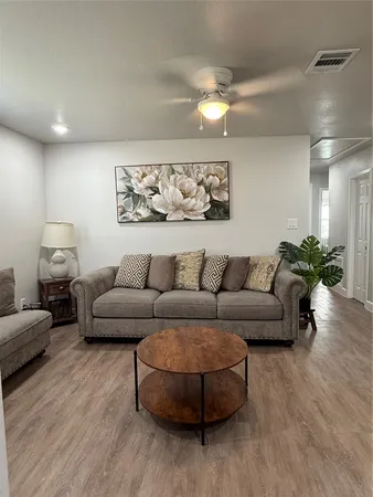 a living room with furniture and wooden floor