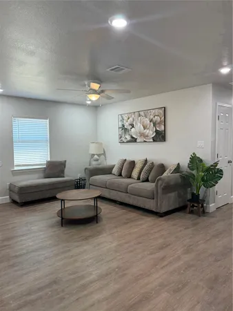 a living room with furniture and a wooden floor